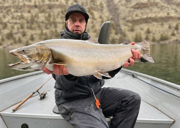 Ryan Mejaski of Bend holds large, possibly record bull trout he caught on April 8 in Lake Billy Chinook