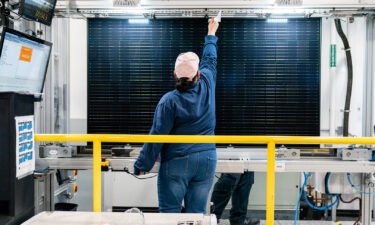 A quality control worker checks a solar panel at the Hanwha QCells solar cell and module manufacturing facility in Dalton