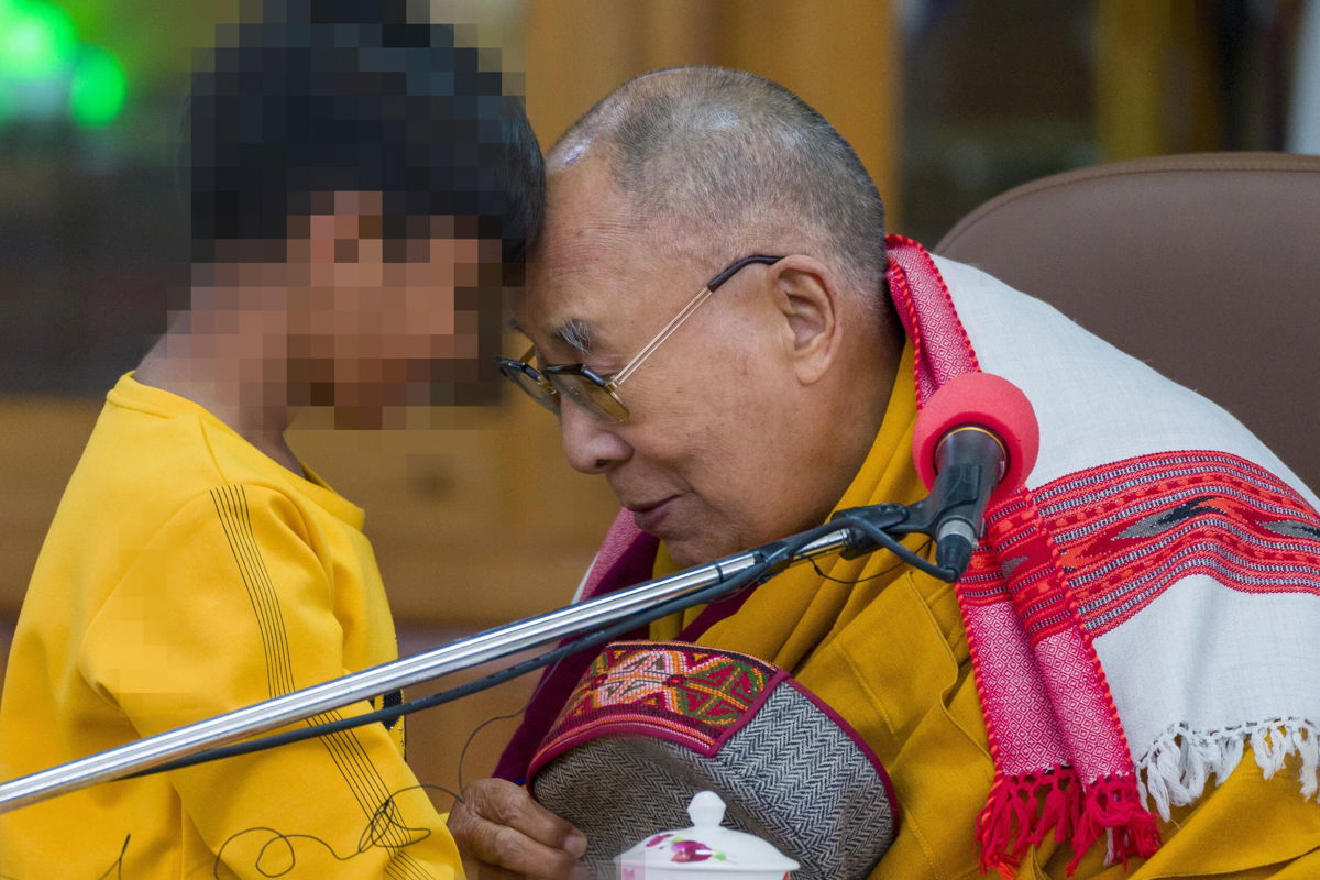 <i>Ashwini Bhatia/AP</i><br/>Tibetan spiritual leader the Dalai Lama touches foreheads with a young boy