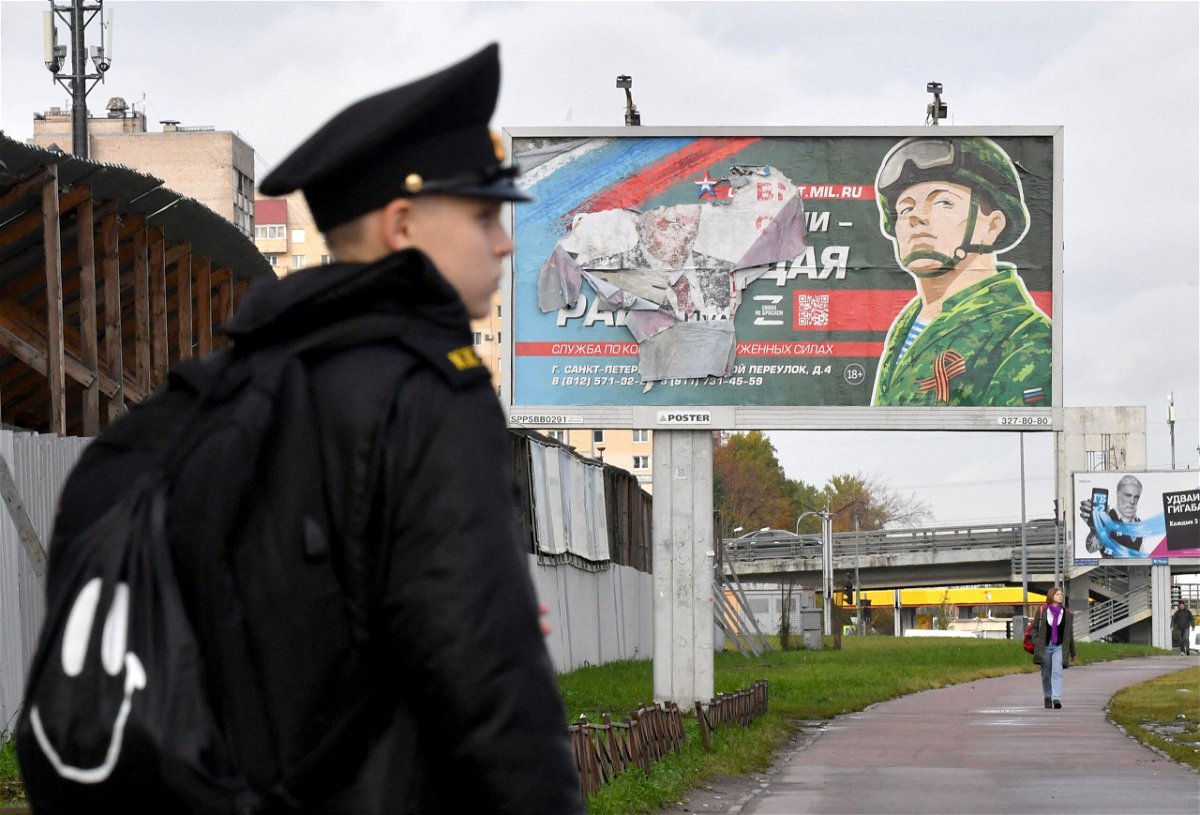 <i>Olga Maltseva/AFP/Getty Images</i><br/>A military cadet stands in front of a billboard promoting contract army service in Saint Petersburg on October 5