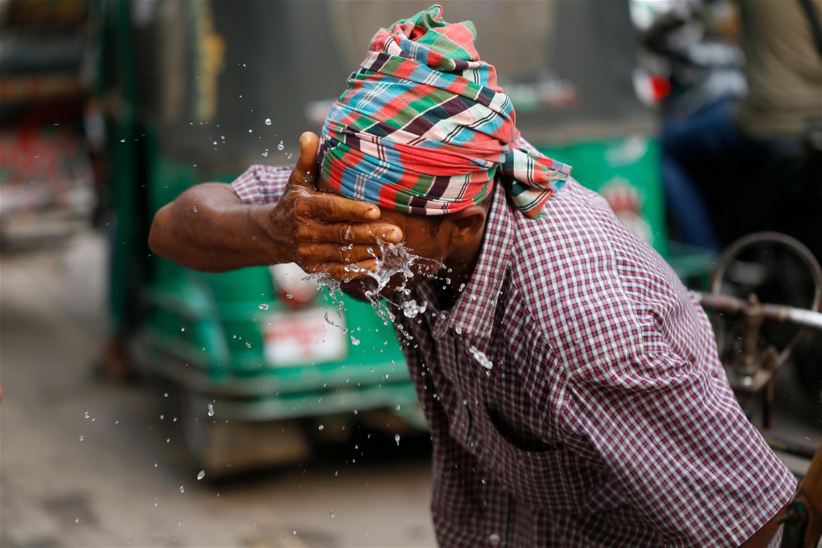 <i>Rehman Asad/NurPhoto/Getty Images</i><br/>A rickshaw puller splashes water on his face to get relief during a heatwave in Dhaka