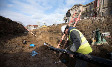 A worker for a geothermal heating and cooling company works in Lansing