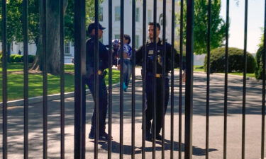 Secret Service uniformed division police officers carry a young child who crawled through the White House fence on Tuesday