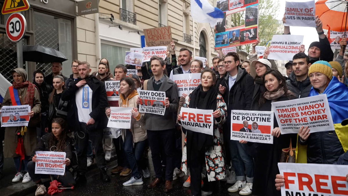 <i>CNN</i><br/>Protestors hold up signs outside an upscale apartment building in Paris on April 23