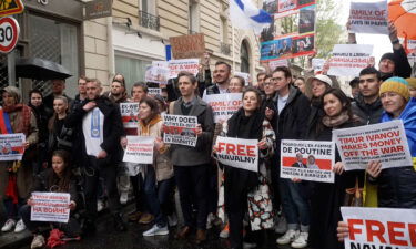 Protestors hold up signs outside an upscale apartment building in Paris on April 23