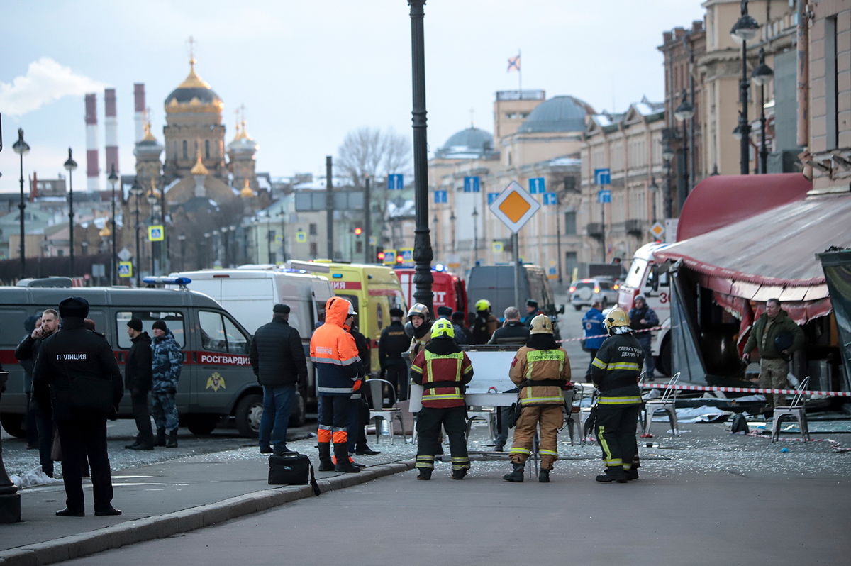 <i>Stringer/AP</i><br/>Emergency service workers stand at the site of the blast at the St. Petersburg cafe on Sunday. Russian authorities have