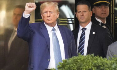 Former President Donald Trump reacts as he leaves his apartment building in New York on Thursday