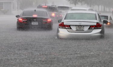 Cars are parked in a flooded street Wednesday in Dania Beach