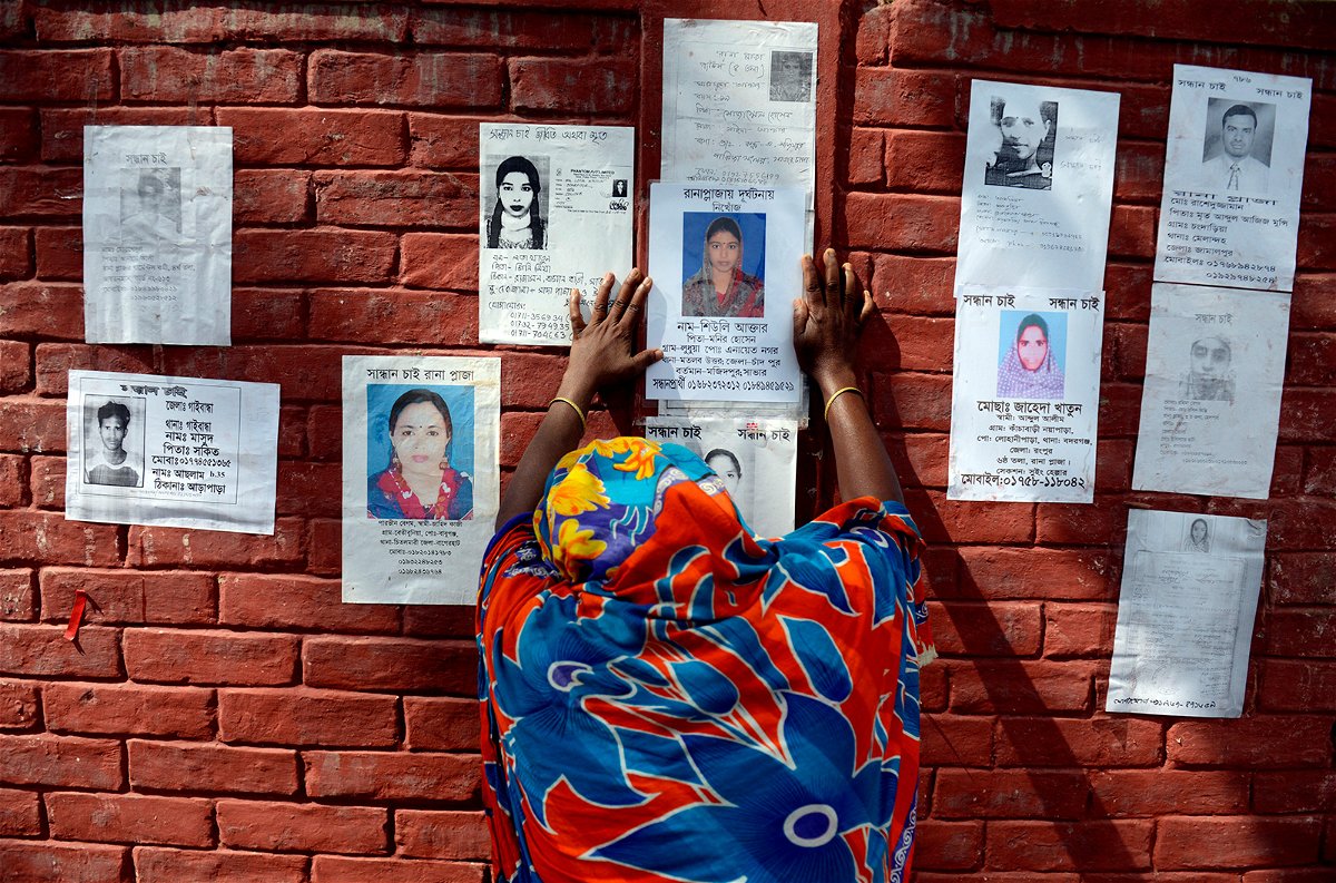 <i>Ismail Ferdous/AP</i><br/>A woman grieves before a poster of her family member on the wall of a school turned into a make-shift morgue on April 30