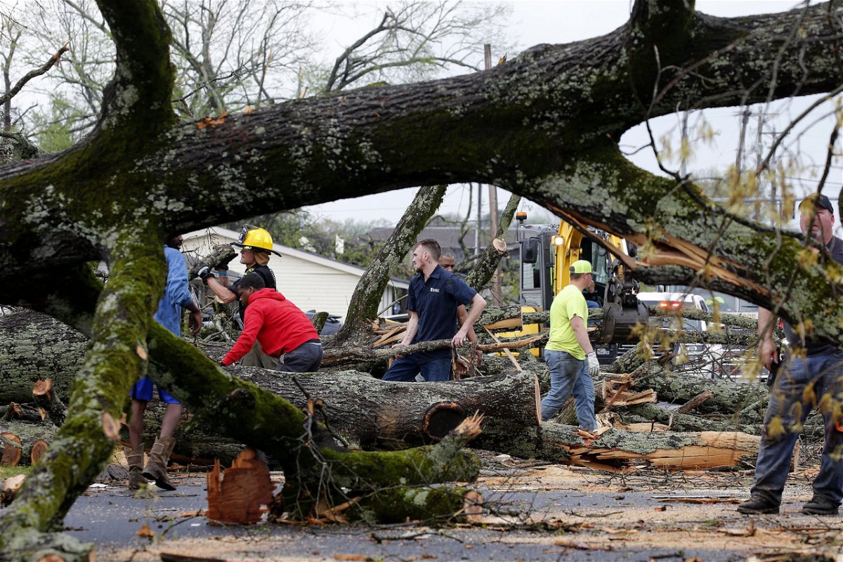 <i>Thomas Metthe/Arkansas Democrat-Gazette/AP</i><br/>Police and firefighters get help from volunteers clearing downed trees on Keihl Avenue after storms ripped through the area on Friday in Sherwood