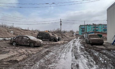 Cars are shown covered in volcanic dust following the eruption.