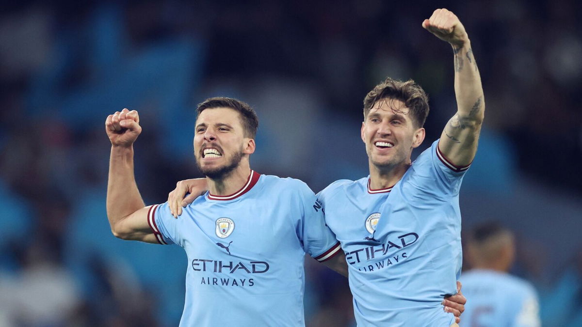 <i>Clive Brunskill/Getty Images</i><br/>Rúben Dias and John Stones celebrate beating Real Madrid on Wednesday.