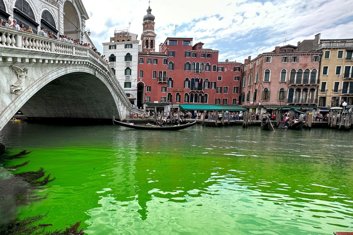 <i>Luigii Costantini/AP</i><br/>Gondolas navigate by the Rialto Bridge on Venice's historical Grand Canal as a patch of phosphorescent green liquid spreads in it