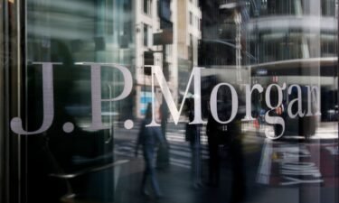 People are reflected into a J.P.Morgan Chase & Co window on April 14 in New York City. JPMorgan is letting go of about 500 employees across the bank.