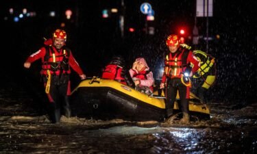 Firemen and civil protection rescuers evacuate a woman with an inflatable boat in the city of Forli in Italy's northern Emilia-Romagna region on Wednesday following severe flooding.