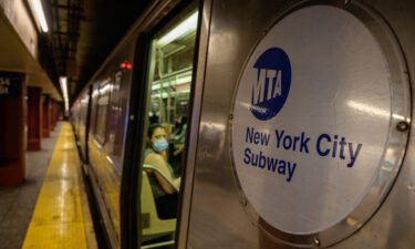 A Metropolitan Transportation Authority (MTA) logo is displayed on the side of a subway train in Manhattan