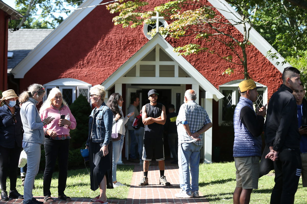 <i>Jonathan Wiggs/The Boston Globe/Getty Images</i><br/>Volunteers mingle outside of St. Andrews Episcopal Church after two planes of migrants from Venezuela arrived on Martha's Vineyard in September 2022. Florida Gov. Ron DeSantis is taking steps to once again send migrants to Democratic-led cities.