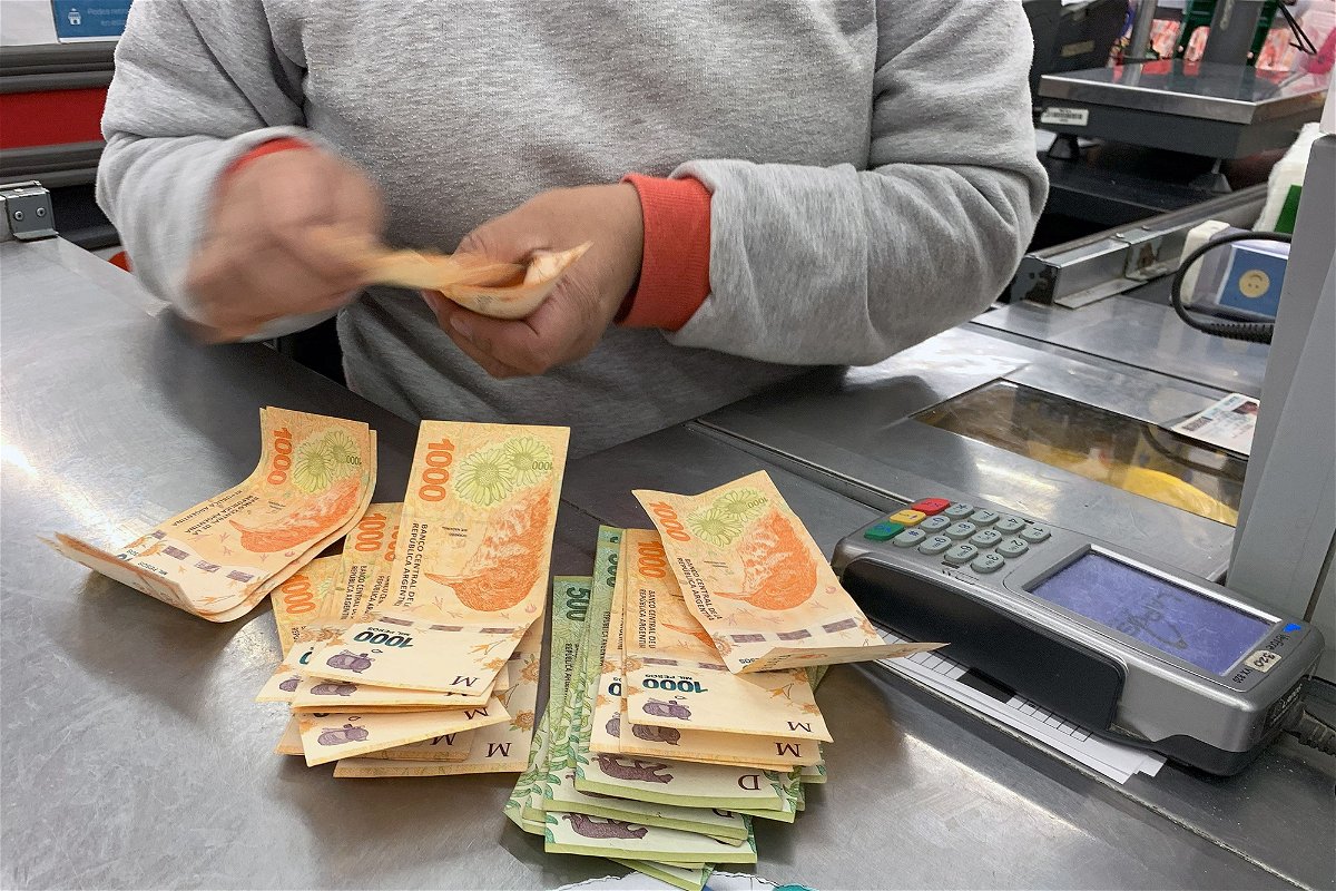 <i>STR/AFP/Getty Images</i><br/>A cashier counts Argentine pesos bills at a supermarket in Buenos Aires
