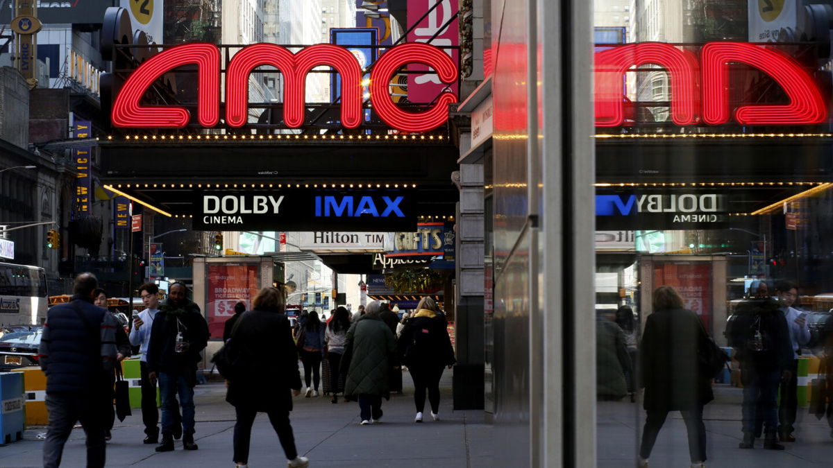 <i>Leonardo Munoz/VIEWpress/Getty Images</i><br/>People make their way near an AMC Theatre on March 29 in New York City. Movie theater companies could be hurt most by the Writers Guild of America strike.
