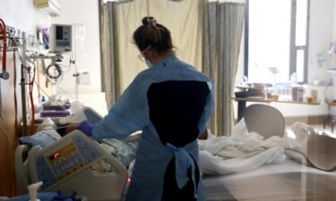Nurse Elisa Gilbert checks on a patient in the Covid-19 unit at the Harborview Medical Center in January 2022 in Seattle