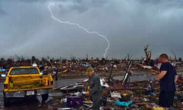 Lightning strikes as tornado survivors search for items at their devastated home on May 23