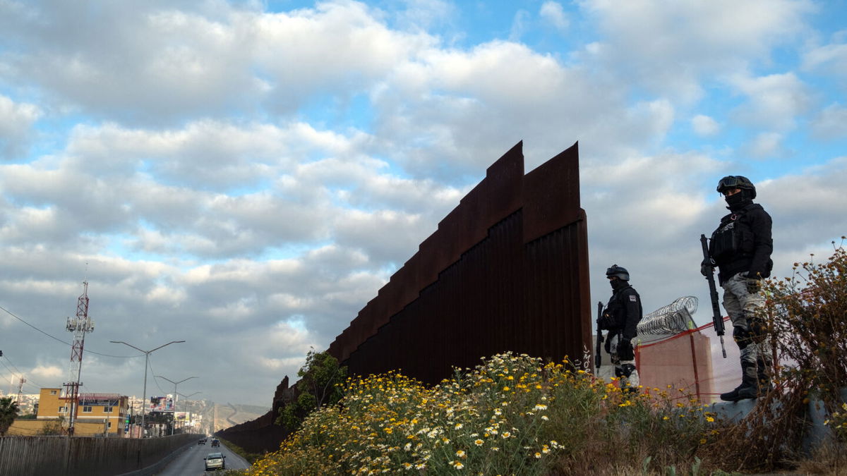 <i>Guillermo Arias/AFP/Getty Images</i><br/>Mexican National Guard officers in Tijuana guard an open section of the US-Mexico border wall on May 6