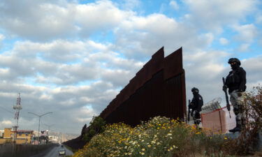 Mexican National Guard officers in Tijuana guard an open section of the US-Mexico border wall on May 6