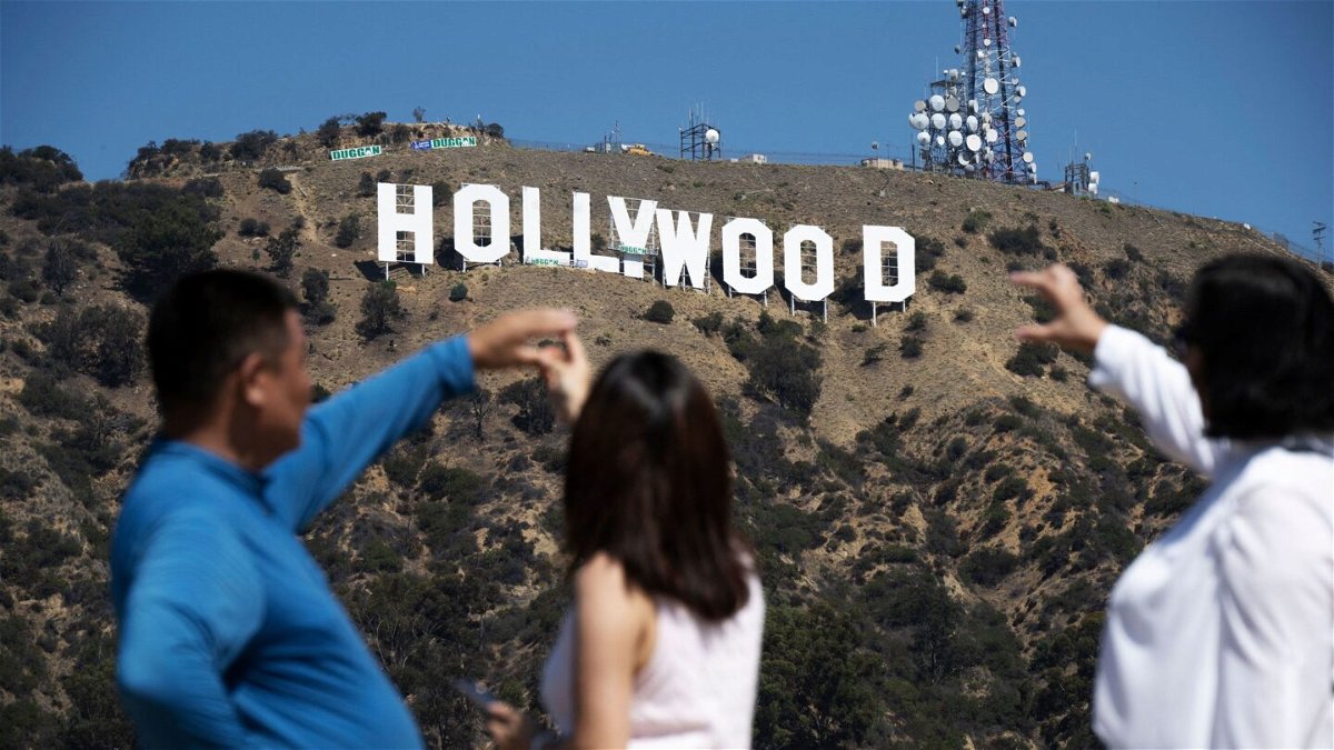 <i>Robyn Beck/AFP/Getty Images</i><br/>Visitors pose for snapshots in front of the Hollywood sign as it is repainted in preparation for its 100th anniversary in 2023