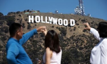 Visitors pose for snapshots in front of the Hollywood sign as it is repainted in preparation for its 100th anniversary in 2023