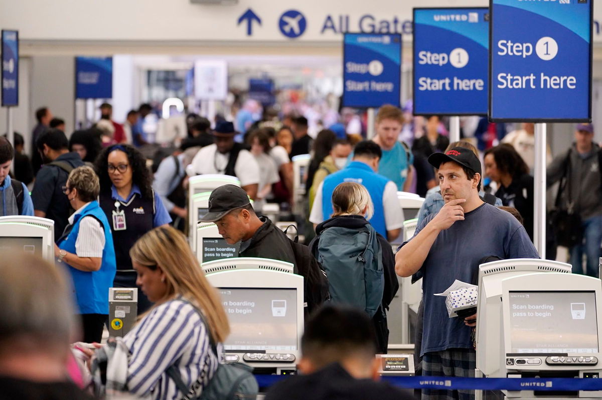 <i>Damian Dovarganes/AP</i><br/>Travelers wait in line at the departure area check-in at the United Airlines terminal at Los Angeles International airport