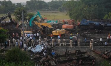 Policemen stand guard at the site where the trains derailed