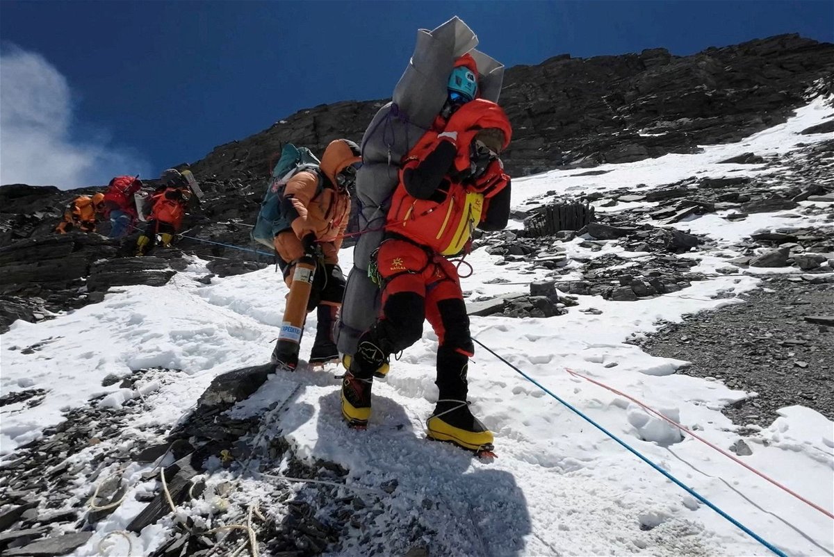 <i>Gelje Sherpa/Reuters</i><br/>Ngima Tashi Sherpa carries a Malaysian climber while rescuing him from the 