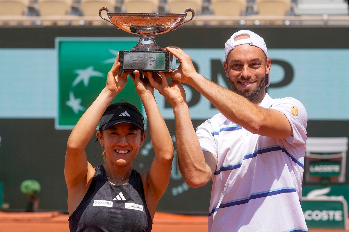 <i>Thibault Camus/AP</i><br/>Japan's Miyu Kato and Tim Puetz hold the trophy after winning the mixed doubles final at the French Open.