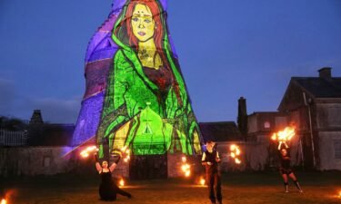 Dancers perform in front of an image of St. Brigid projected onto The Wonderful Barn in Leixlip