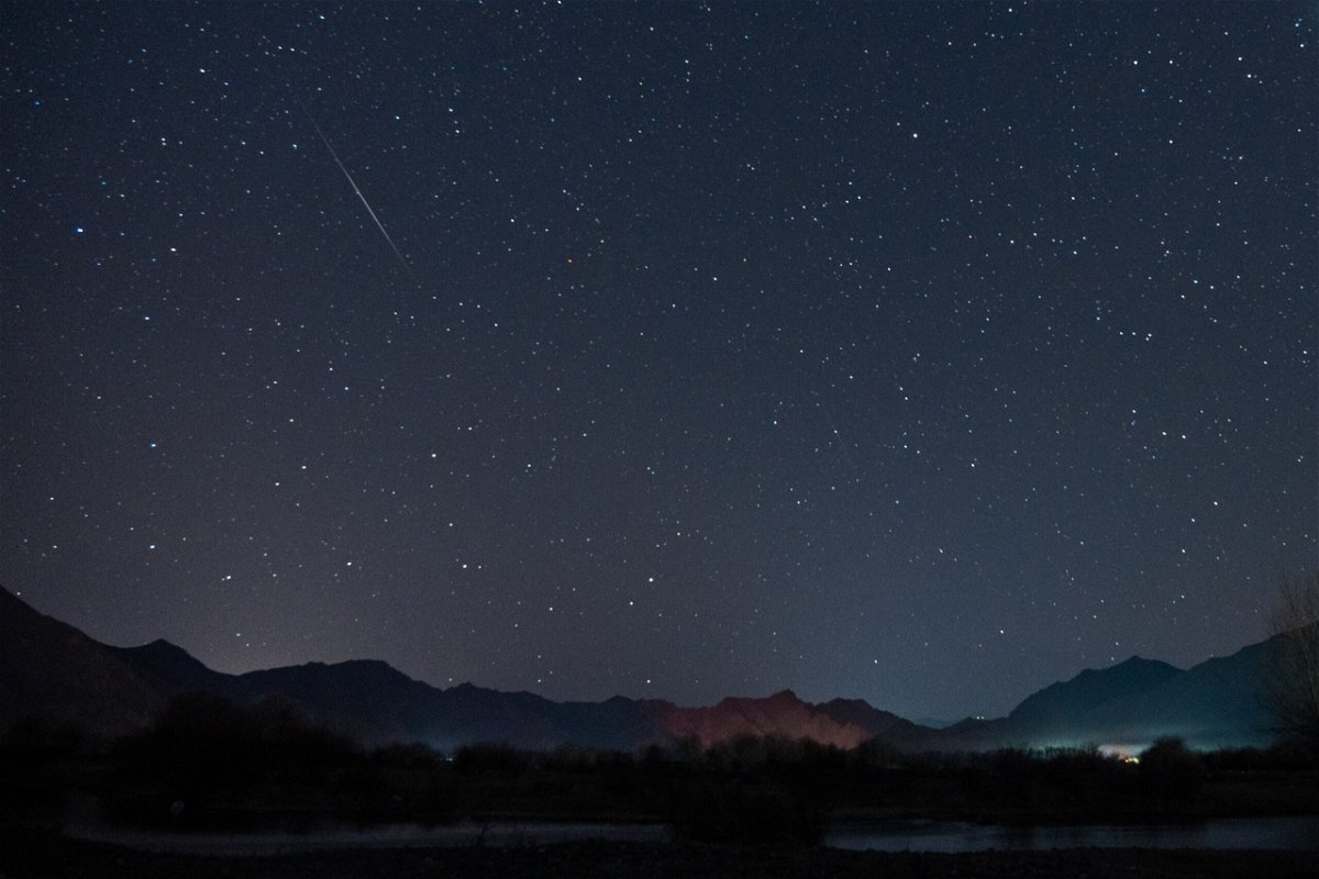 <i>Jiang Feibo/China News Service/Getty Images</i><br/>The Geminid meteor shower streaks across the night sky over the Lhasa River in Tibet on December 14