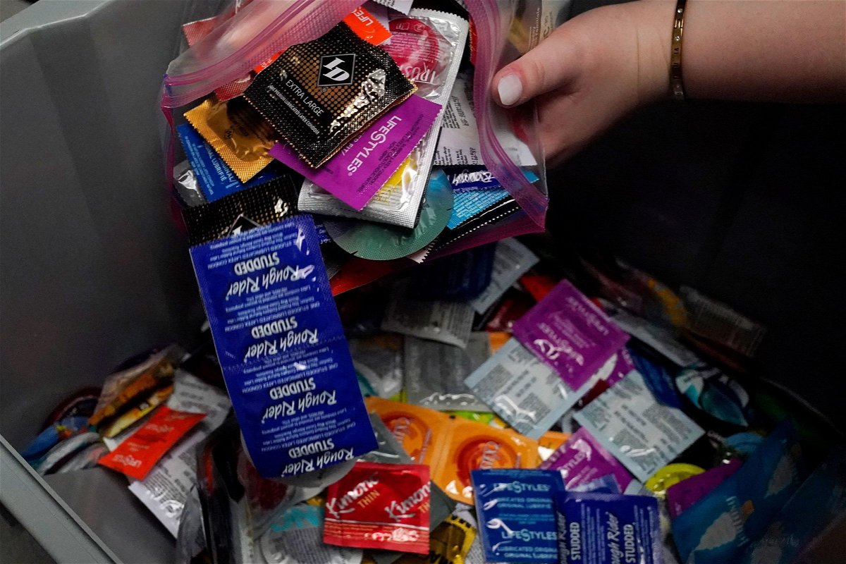 <i>Sue Ogrocki/AP</i><br/>A sexual health peer educator at the University of Oklahoma dumps condoms into a container at the health center on campus in May.