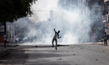 A demonstrator hurls a stone at police in Dakar on June 1 during a protest.