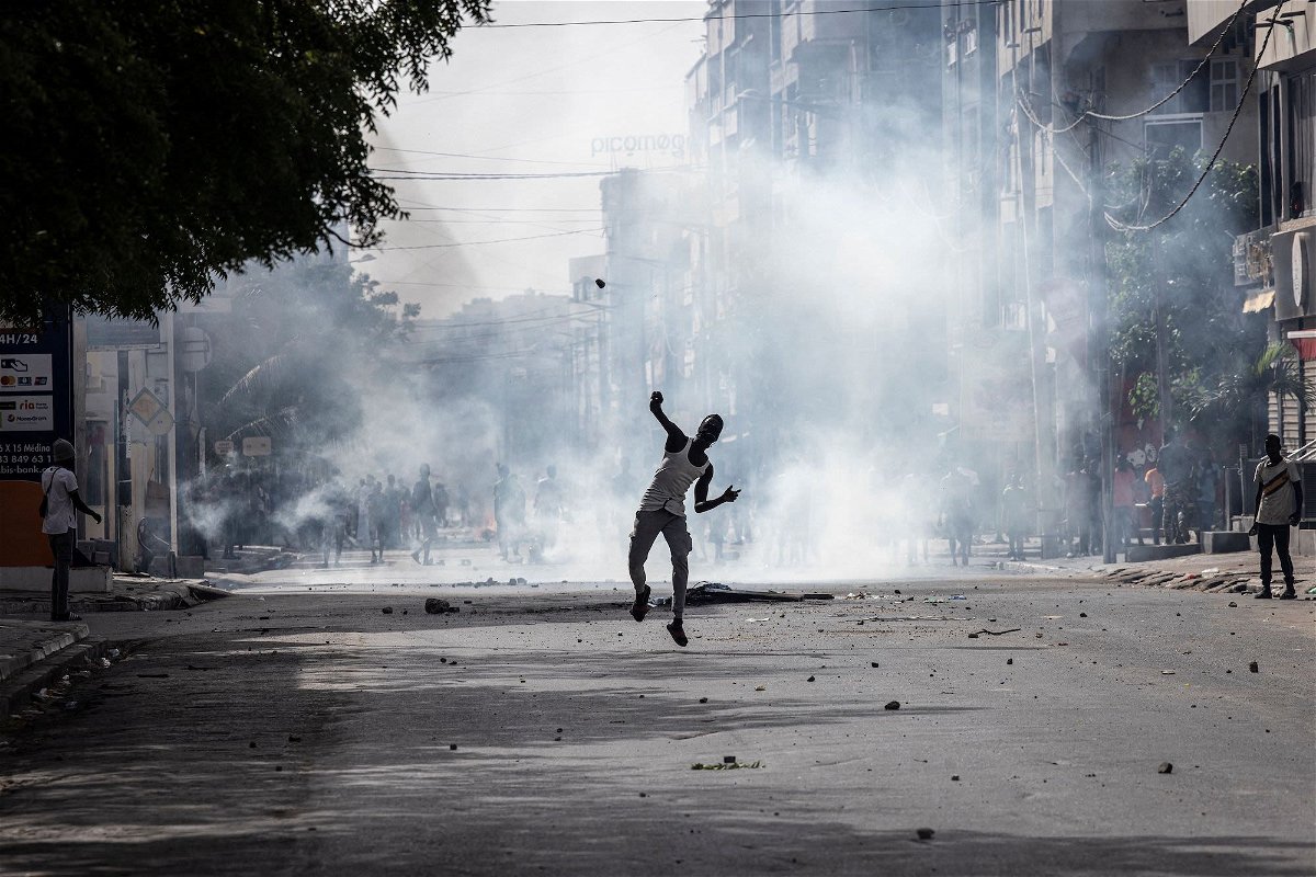 <i>John Wessels/AFP/Getty Images</i><br/>A demonstrator hurls a stone at police in Dakar on June 1 during a protest.