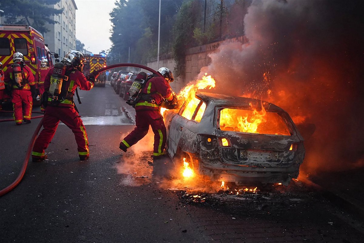 <i>Zakaria Abdelkafi/AFP/Getty Images</i><br/>Firefighters work to put out a burning car at a protest in Nanterre