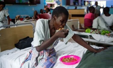 A survivor and a follower of Mackenzie's eats a meal inside a ward at the Malindi sub district hospital in April.