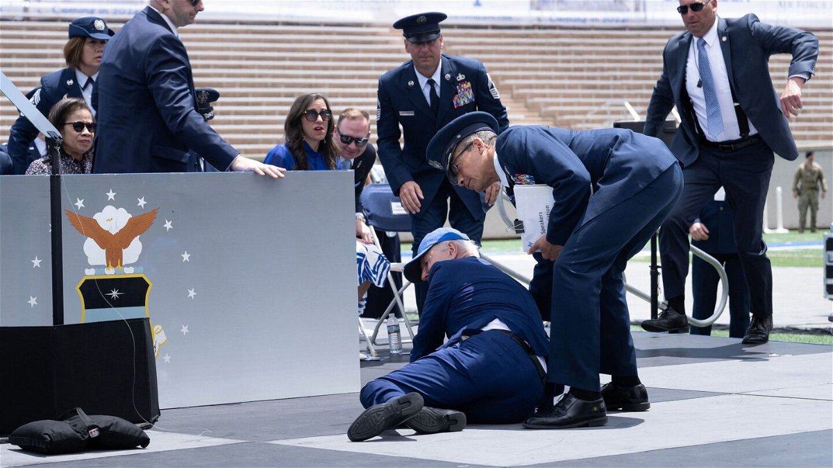 <i>Brendan Smialowski/AFP/Getty Images</i><br/>President Joe Biden is helped up after falling during the graduation ceremony at the United States Air Force Academy