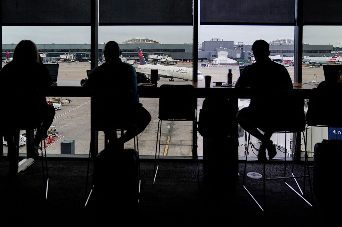 <i>Elijah Nouvelage/Reuters/FILE</i><br/>Passengers are seen in silhouette at a Delta Sky Club as an airplane parks at a gate in front of them at Hartsfield-Jackson Atlanta International Airport ahead of the Fourth of July holiday in Atlanta