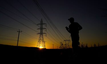 A jogger passes under power lines during an evening run on Monday in San Antonio. Nighttime temperatures will stay dangerously hot this week