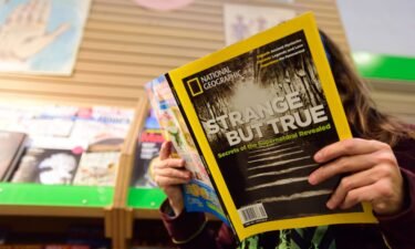 A woman reads the current issue of National Geographic at Powell's City of Books in Portland