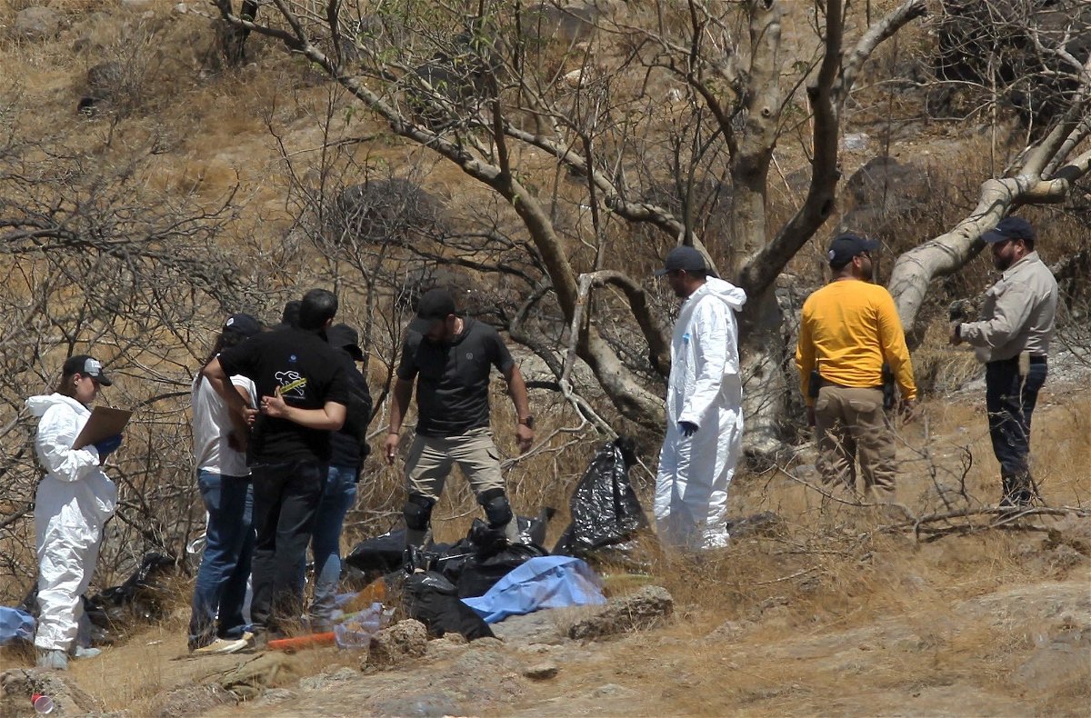<i>Ulises Ruiz/AFP/Getty Images</i><br/>Forensic experts work with several bags of human remains extracted from the bottom of a ravine by a helicopter