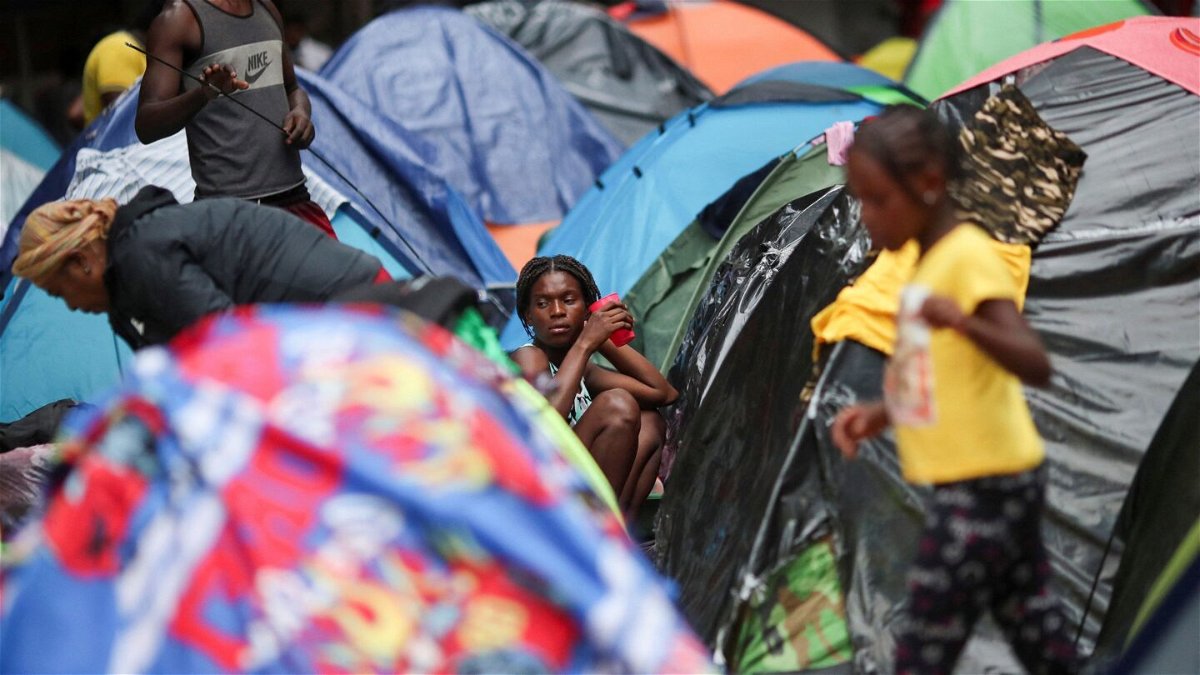 <i>Henry Romero/Reuters</i><br/>Migrants from Haiti look on outside their tent in the Giordano Bruno park