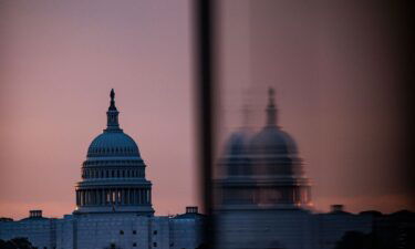 The US Capitol building is seen from the base of the Washington Monument as the sun rises in Washington