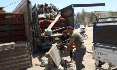 People inspect a damaged truck at the fruit and vegetable market following a reported airstrike in Idlib