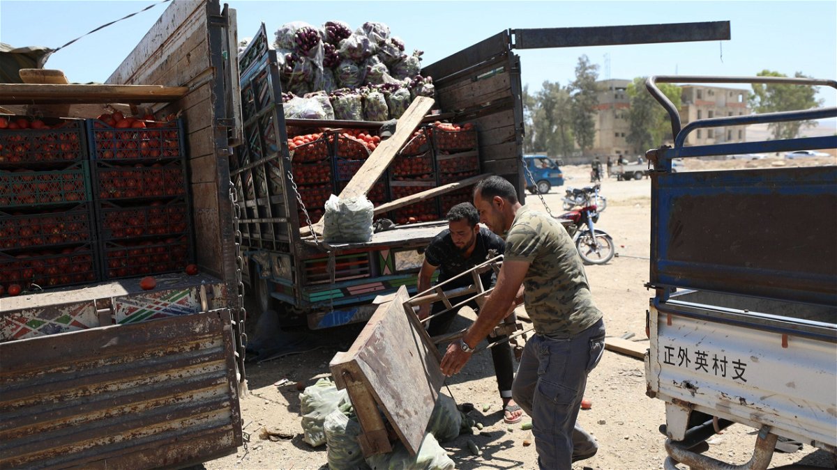 <i>Yahya Nemah/EPA-EFE/Shutterstock</i><br/>People inspect a damaged truck at the fruit and vegetable market following a reported airstrike in Idlib