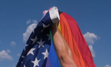 A vendor takes down a US flag while breaking down a booth after an all ages LGBTQ Pride event in Franklin